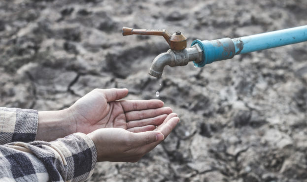 Cropped Image Of Hands Catching Water Drop Falling From Faucet During Drought