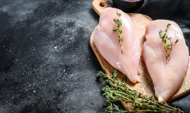 raw-chicken-breast-fillet-chopping-board-with-herbs-spices-black-background-top-view-copy-space_89816-11102