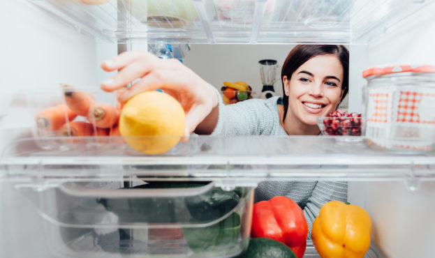 Woman taking a lemon out of the fridge