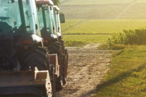 row-of-agriculture-tractors-in-front-of-vineyard-BQGXN74-min-scaled